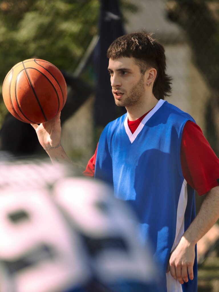 [ALT_TEXT: Un joven con un corte mullet con degradado jugando al baloncesto.]