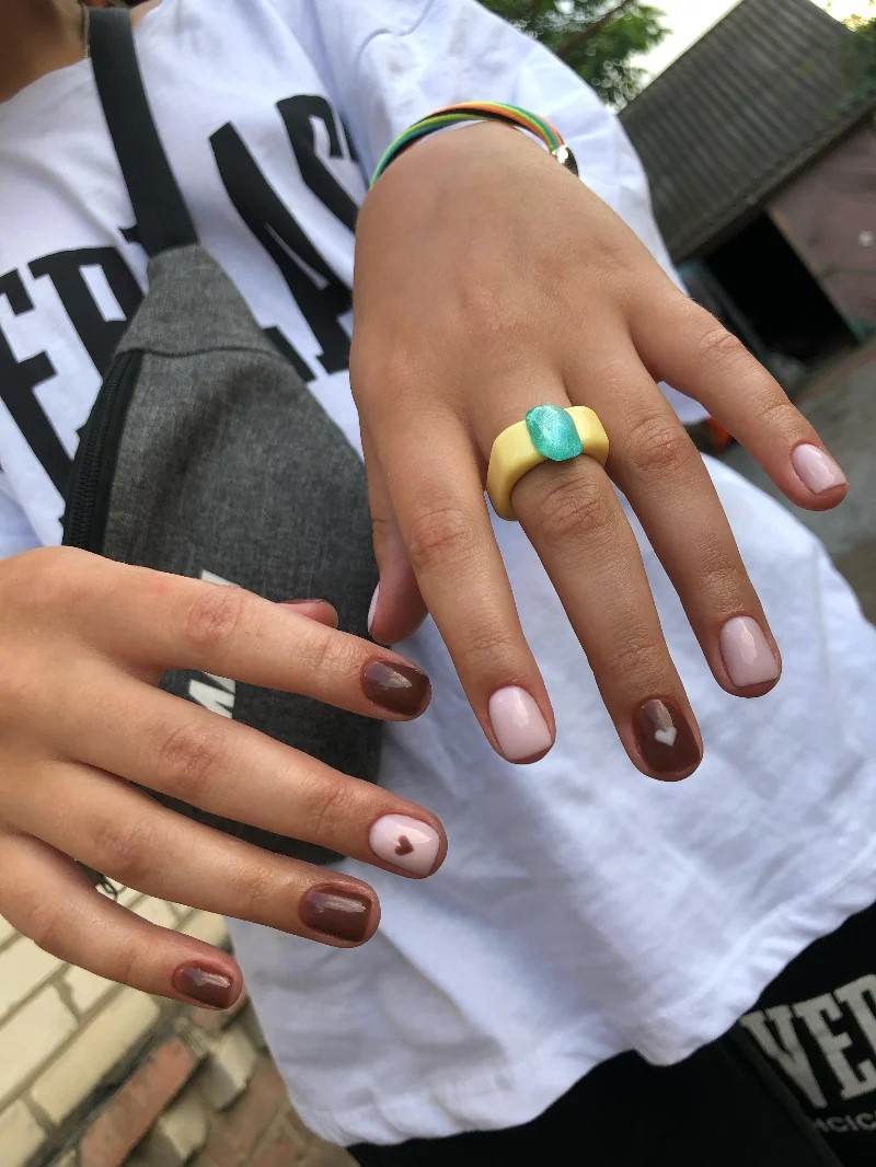 Mujer con camiseta blanca en exteriores mostrando su manicura BIAB a la cmara