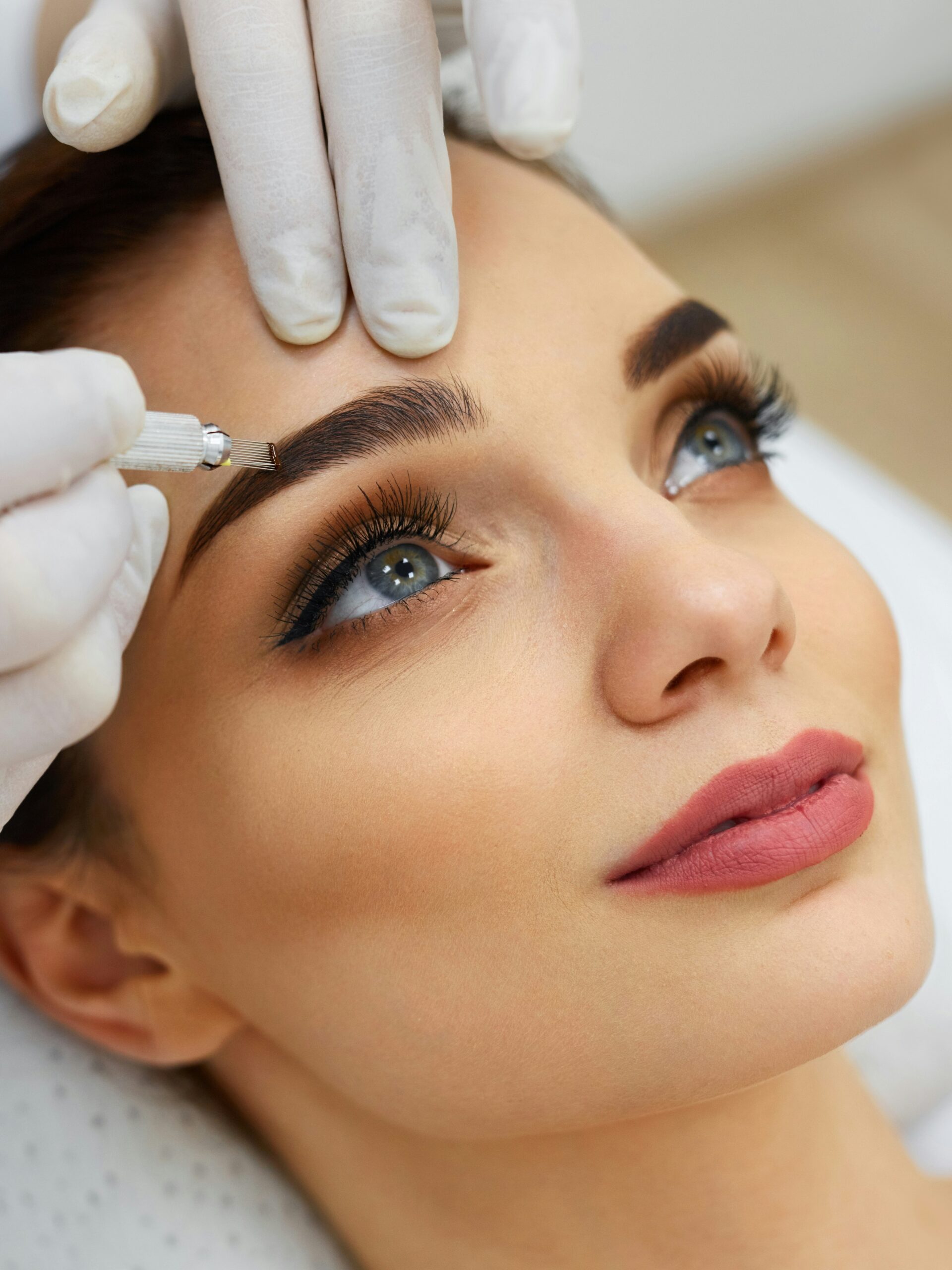 Primer plano del rostro de una mujer en un salón de belleza mientras recibe un tratamiento de microblading