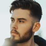 Hombre de pie al aire libre con cabello oscuro y un taper fade con la parte superior texturizada
