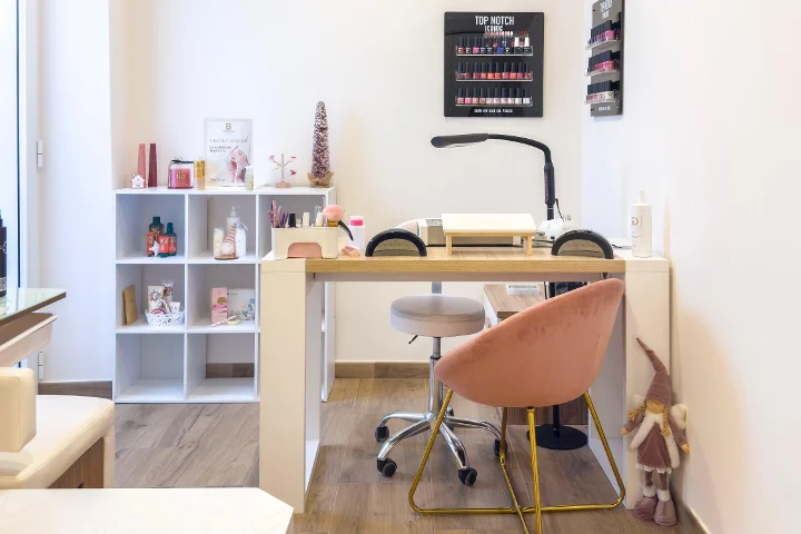 Puesto de manicura en Gd Beauty Clinc di Giulia Delogu en Alghero con sillón de terciopelo rosa y expositor de esmaltes Top Notch.