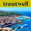Vista aérea de un pueblo costero sardo con casas de colores pastel, puerto pequeño y mar turquesa.