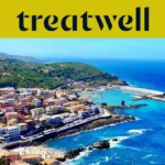 Vista aérea de un pueblo costero sardo con casas de colores pastel, puerto pequeño y mar turquesa.