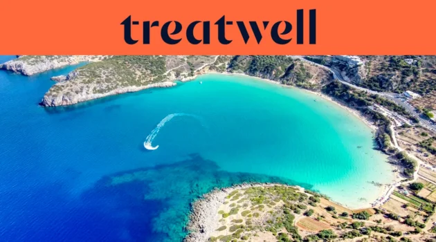 Vista aérea de una bahía cretense turquesa, con una moto de agua trazando una curva blanca por el agua clara, una media luna de playa de arena y colinas secas alrededor de la orilla, bajo un banner naranja coral con la palabra treatwell.