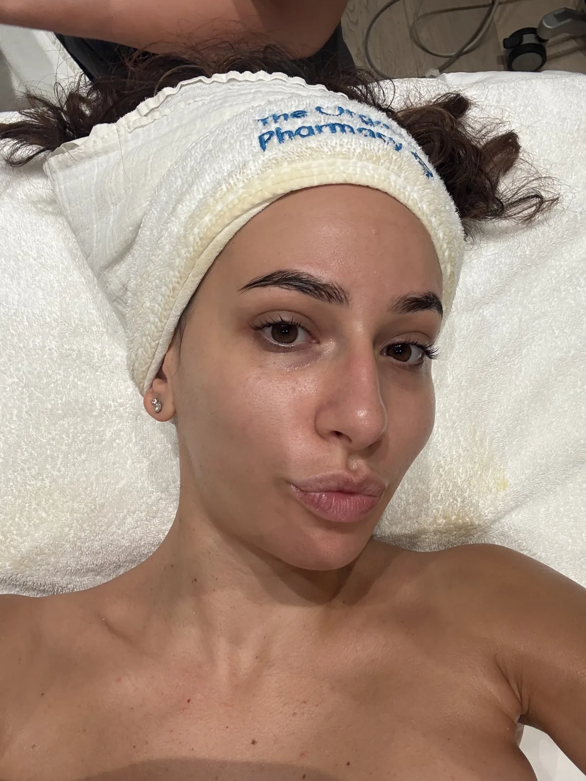 Mujer con la piel fresca y luminosa y una cinta en el pelo durante un facial
